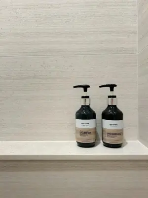 two bottles of soap sitting on a shelf at PHYLL Condo Private Beach Vibes at Central Phuket 1 BR Unique Garden View in Ban Rangeng