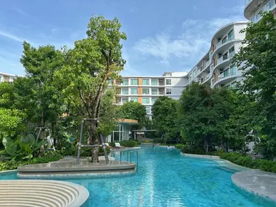 a swimming pool in front of a building at PHYLL Condo Private Beach Vibes at Central Phuket 1 BR Unique Garden View in Ban Rangeng