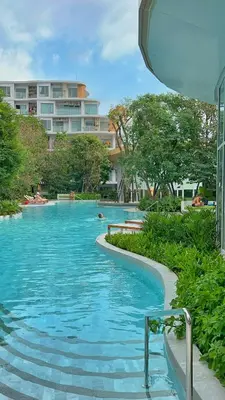a swimming pool in front of a building at PHYLL Condo Private Beach Vibes at Central Phuket 1 BR Unique Garden View in Ban Rangeng