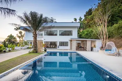 a house with a swimming pool in front of a house at Sirinary Villa Phuket in Ban Ao Makham