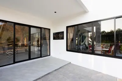 a room with large glass windows on a wall at Sirinary Villa Phuket in Ban Ao Makham