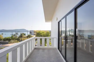 a balcony with glass doors and a view of the ocean at Sirinary Villa Phuket in Ban Ao Makham