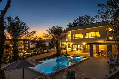 a house with a swimming pool in front of a house at Sirinary Villa Phuket in Ban Ao Makham