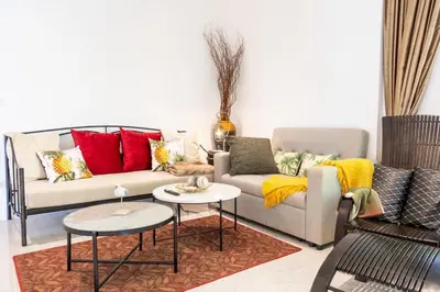 a living room with a couch and two tables at Sirinary Villa Phuket in Ban Ao Makham