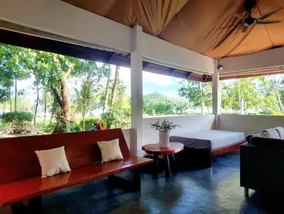 a living room with a couch and a bed and a table at House On The Bay2, Koh Yao in Ko Yao Noi