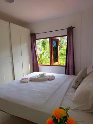 a bedroom with a large white bed with a window at House On The Bay2, Koh Yao in Ko Yao Noi