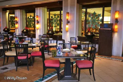 a restaurant with tables and chairs in a building at Karon Beachfront Apartment 724 in Karon Beach