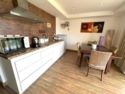 a kitchen with a counter and a table with chairs at Sea view Kata apartment near Santosa SPA D5 in Kata Beach