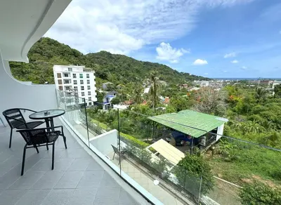a balcony with a table and a view of a city at Sea view Kata apartment near Santosa SPA D5 in Kata Beach