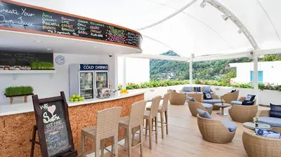 a restaurant with tables and chairs and a bar at Sea view Kata apartment near Santosa SPA D5 in Kata Beach