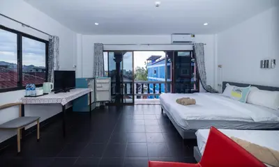 a bedroom with a bed and a desk with a computer at Belle Cose Guest House Phuket in Patong Beach