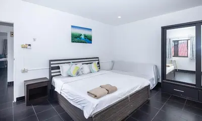 a bedroom with a large bed with white sheets and pillows at Belle Cose Guest House Phuket in Patong Beach