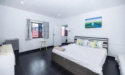 a bedroom with a large bed and a couch at Belle Cose Guest House Phuket in Patong Beach
