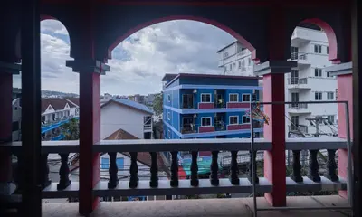 a view of a blue building from a balcony at Belle Cose Guest House Phuket in Patong Beach