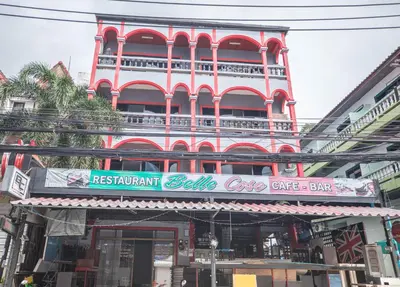 a red building with a sign in front of it at Belle Cose Guest House Phuket in Patong Beach
