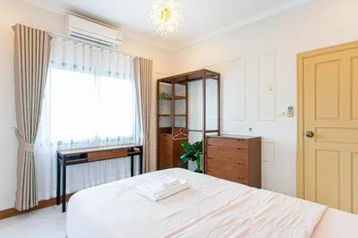 a bedroom with a white bed and a window at Chalong V pool villa in Ban Klang