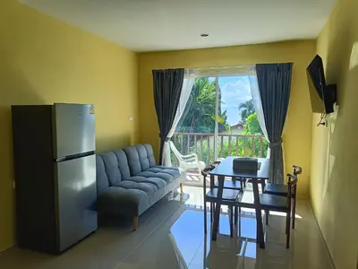 a kitchen with a couch and a table and a refrigerator at Yellow house in Ban Saiyuan (1)