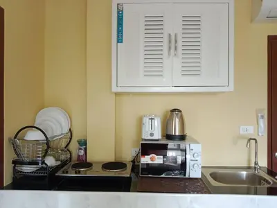 a kitchen counter with a microwave and a sink at Yellow house in Ban Saiyuan (1)