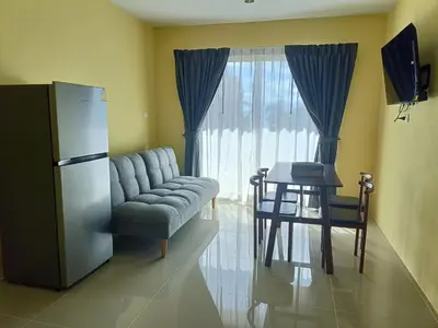 a living room with a refrigerator and a chair and a table at Yellow house in Ban Saiyuan (1)