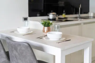 a white table with two bowls on it in a kitchen at Spacious Pool View 1BR Apartment in Utopia Naiharn Residence near Beach, UTN D604 in Rawai Beach