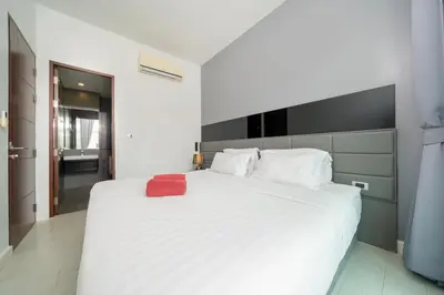 a bedroom with a white bed with a red towel on it at Spacious Pool View 1BR Apartment in Utopia Naiharn Residence near Beach, UTN D604 in Rawai Beach