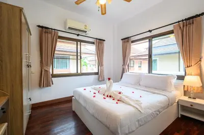 a bedroom with a white bed with roses on it at San pool villa in Patong Beach