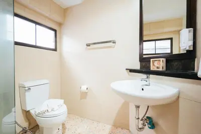 a bathroom with a sink and a toilet and a mirror at San pool villa in Patong Beach