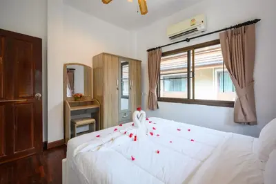 a bedroom with a white bed with red roses on it at San pool villa in Patong Beach