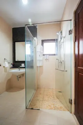a bathroom with a glass shower and a sink at San pool villa in Patong Beach