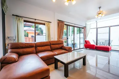 a living room with a leather couch and a table at San pool villa in Patong Beach