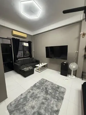 a living room with a couch and a flat screen tv at Green Dreams Guesthouse in Ban Lo Long