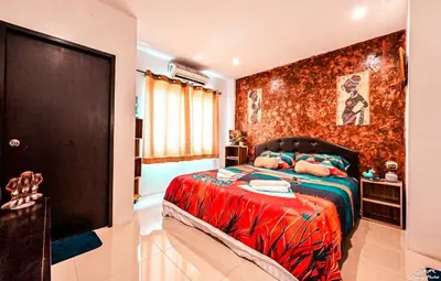 a bedroom with a bed with a red wall at DANK Hotel 420 friendly Patong Phuket in Patong Beach