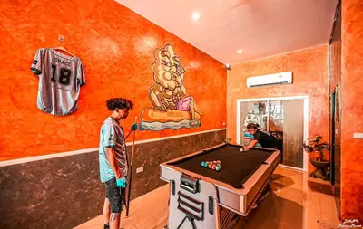 two men standing in a room with a pool table at DANK Hotel 420 friendly Patong Phuket in Patong Beach