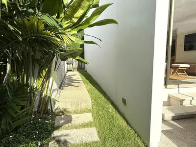 a garden with grass and plants next to a building at Luxury 3BR Pool Villa near Blue Tree - Bang Tao in Amphoe Kathu