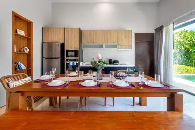 a dining room with a table and a kitchen at \u5bbd\u655e\u8212\u9002 \u90a6\u6d9b\u6d77\u6ee9Laguna\u9644\u8fd1 \u56db\u5367\u5ba4\u79c1\u4eba\u6cf3\u6c60\u522b\u5885 V07 in Phuket Town