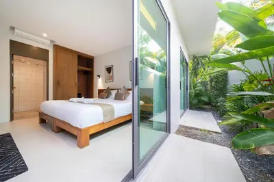 a bedroom with a bed and a glass wall at \u5bbd\u655e\u8212\u9002 \u90a6\u6d9b\u6d77\u6ee9Laguna\u9644\u8fd1 \u56db\u5367\u5ba4\u79c1\u4eba\u6cf3\u6c60\u522b\u5885 V07 in Phuket Town