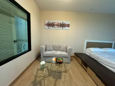 a bedroom with a bed and a chair and a glass table at คอนโดใกล้หาดในทอนNai Thon Beach Room A410 in Nai Thon Beach