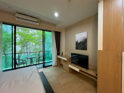 a bedroom with a bed and a television and a table at คอนโดใกล้หาดในทอนNai Thon Beach Room A410 in Nai Thon Beach