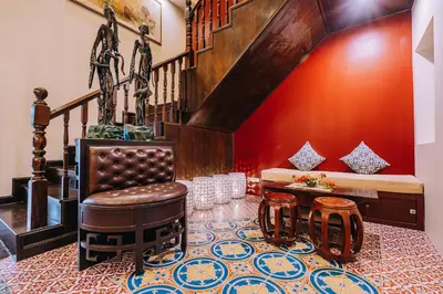 a living room with a staircase and a leather chair at O'nya Phuket Hotel in Phuket Town
