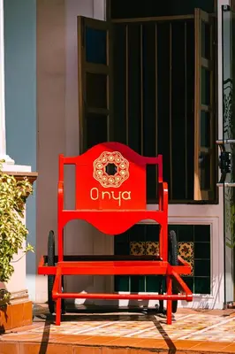 a red bench sitting in front of a building at O'nya Phuket Hotel in Phuket Town