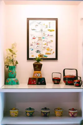 a shelf with vases on it with a picture at O'nya Phuket Hotel in Phuket Town