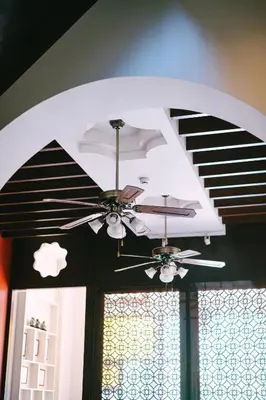 a ceiling fan in a room with a window at O'nya Phuket Hotel in Phuket Town