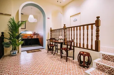 a hallway with a staircase with a table and chairs at O'nya Phuket Hotel in Phuket Town