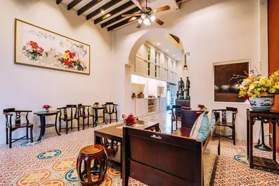 a dining room with tables and chairs and a ceiling at O'nya Phuket Hotel in Phuket Town