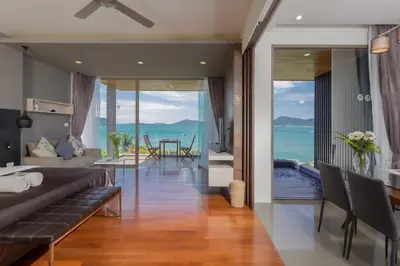 a bedroom with a bed and a view of the ocean at X10 Seaview Suites at Panwa Beach in Panwa Beach