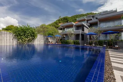 a swimming pool at a resort with a waterfall at X10 Seaview Suites at Panwa Beach in Panwa Beach