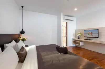 a bedroom with a bed and a tv on a wall at X10 Seaview Suites at Panwa Beach in Panwa Beach