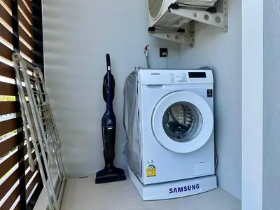 a washing machine in a laundry room next to a staircase at Title V Sunny Nest Sea View 5fl Pool Gym in Rawai Beach