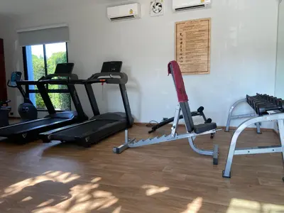 a gym with two treadmills and two exercise bikes at Title V Sunny Nest Sea View 5fl Pool Gym in Rawai Beach