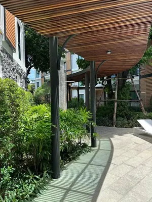 a wooden canopy over a patio with plants and trees at Title V Sunny Nest Sea View 5fl Pool Gym in Rawai Beach